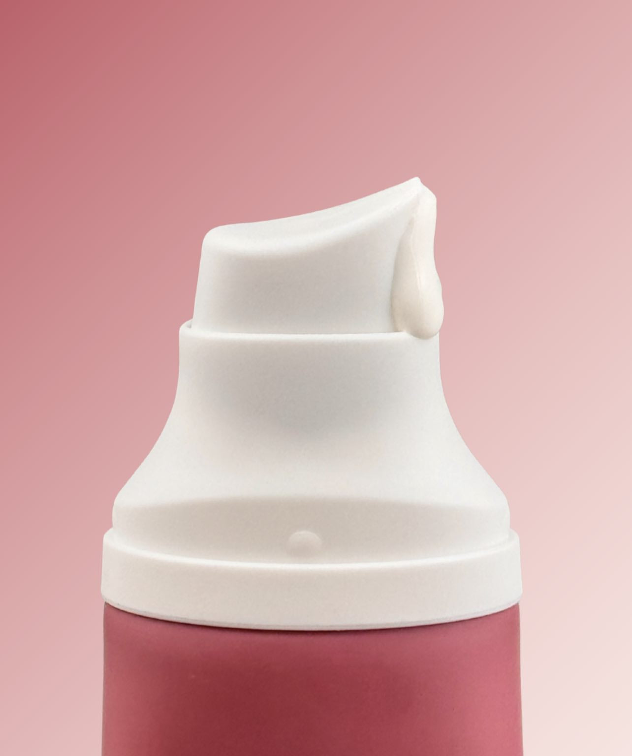 White cap on a pink bottle against a pink background