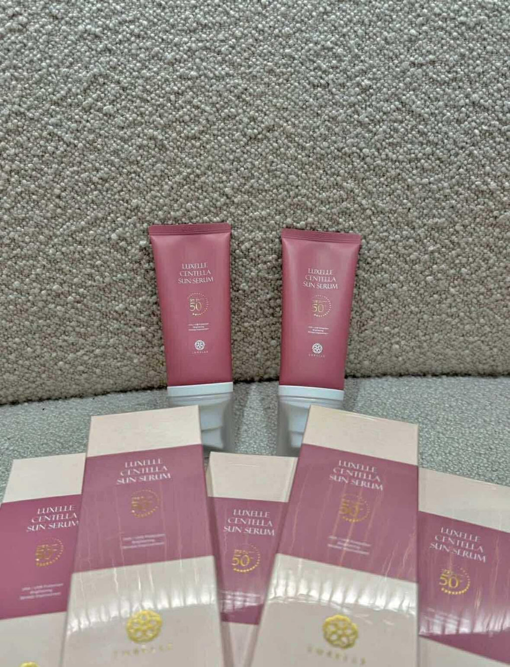 Sunscreen cream tubes and packaging on a textured surface