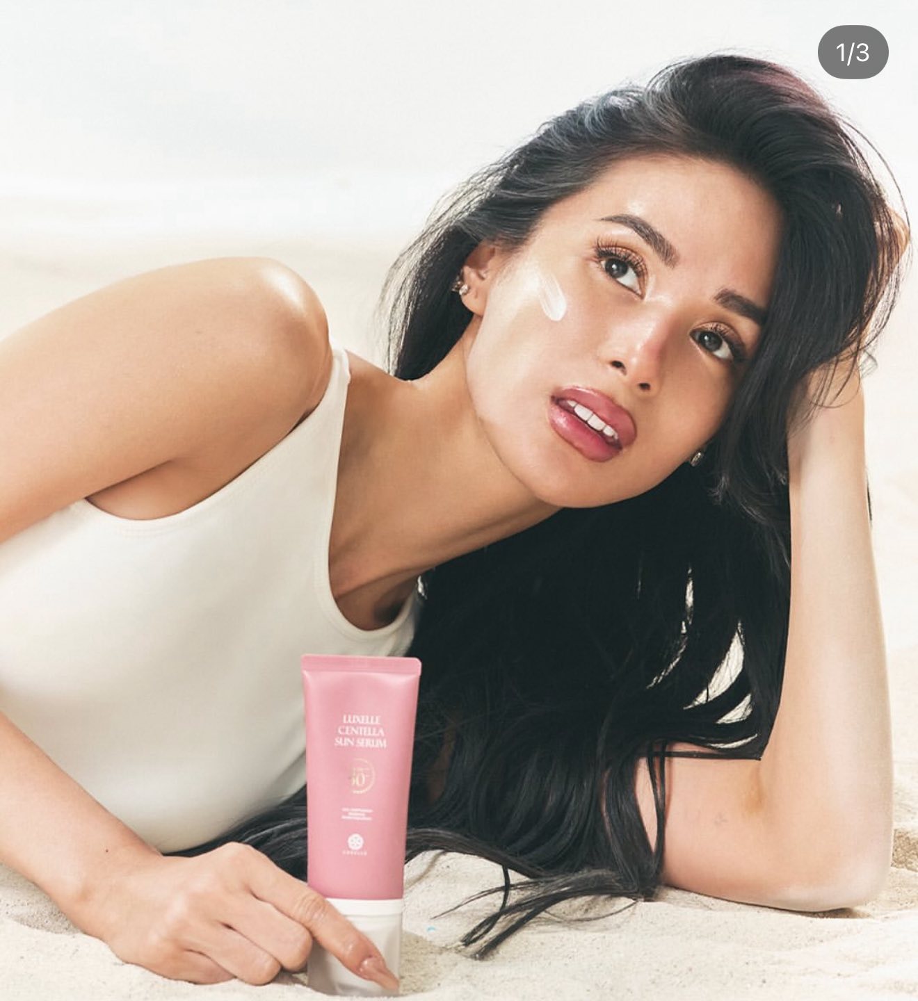 Woman with a pink skincare product on a white background
