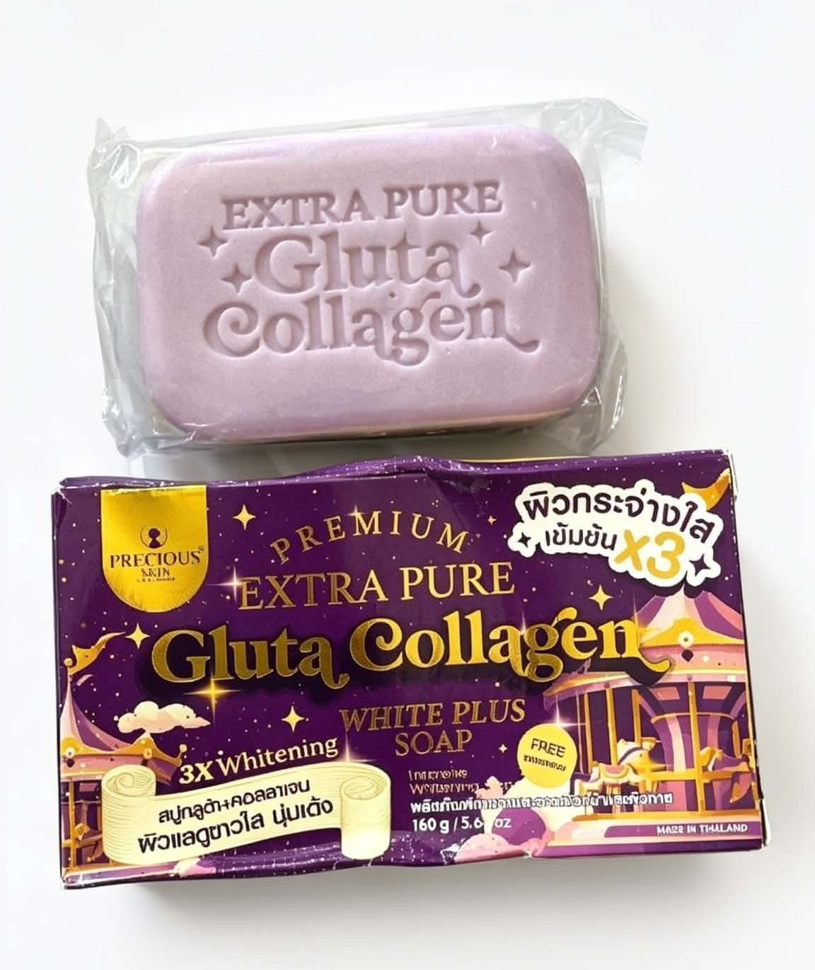 A bar of lavender-colored gluta collagen soap wrapped in clear plastic, placed above its purple and gold retail packaging box on a plain white background.