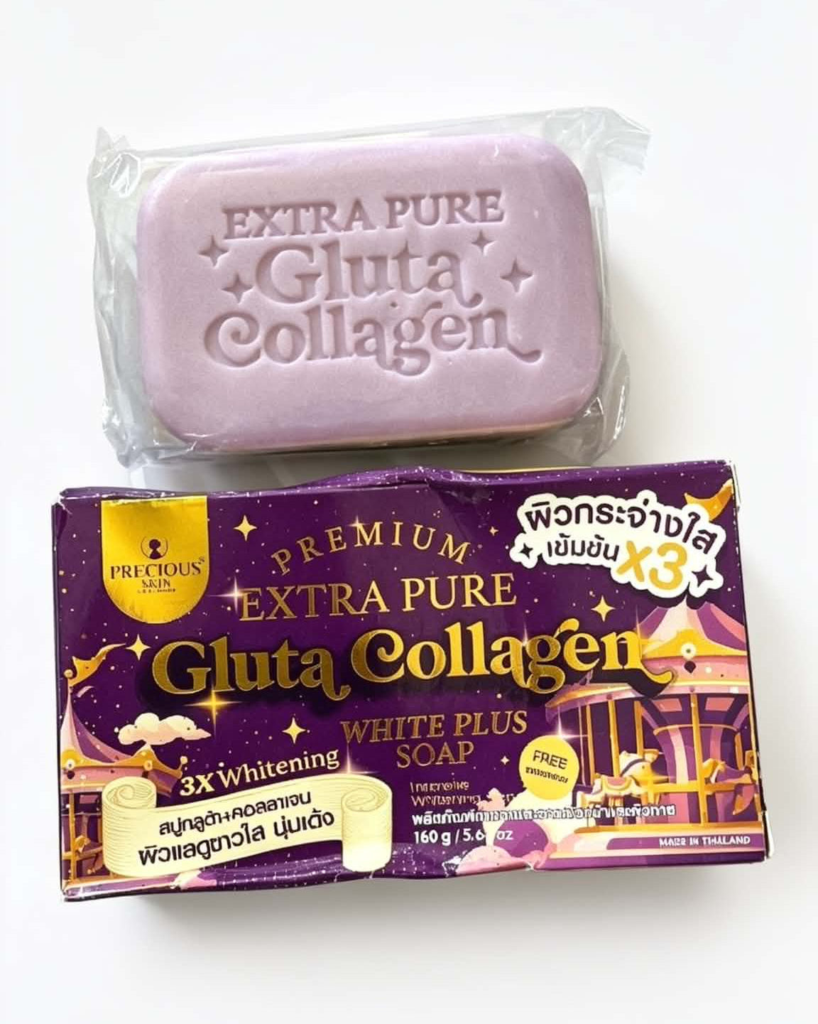 A bar of lavender-colored gluta collagen soap wrapped in clear plastic, placed above its purple and gold retail packaging box on a plain white background.