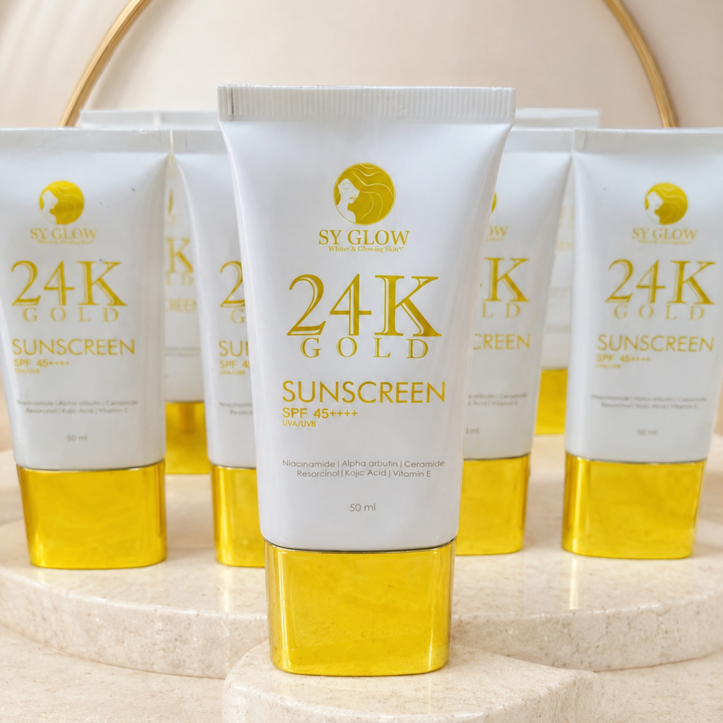 Six tubes of SY GLOW 24K Gold Sunscreen SPF 45+ are arranged on a beige marble pedestal with a gold circular frame in the background.