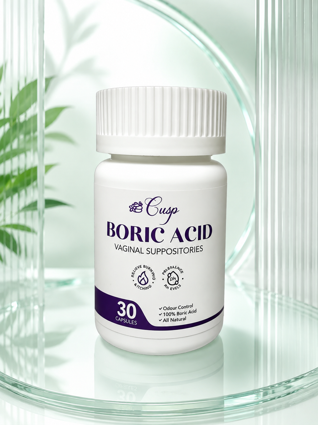 A white plastic bottle of Cusp Boric Acid Vaginal Suppositories with a ribbed white cap, displayed on a reflective glass surface with a soft-focus background of green leaves and glass.