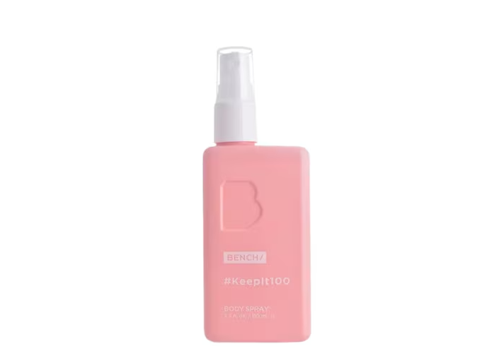 A pink rectangular spray bottle with a white pump dispenser, featuring the brand name BENCH and the shade name #KeepIt100 on the front, set against a plain white background.