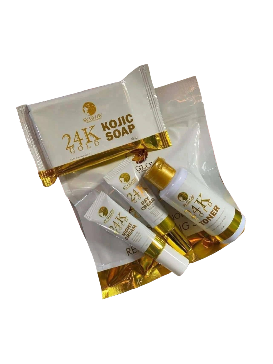 A skincare gift set containing a bar of 24K Gold Kojic Soap, a tube of 24K Gold Hand Cream, a tube of 24K Gold Toner, and a tube of 24K Gold Serum, all in white packaging with gold accents, arranged inside a clear resealable pouch with a gold foil base.