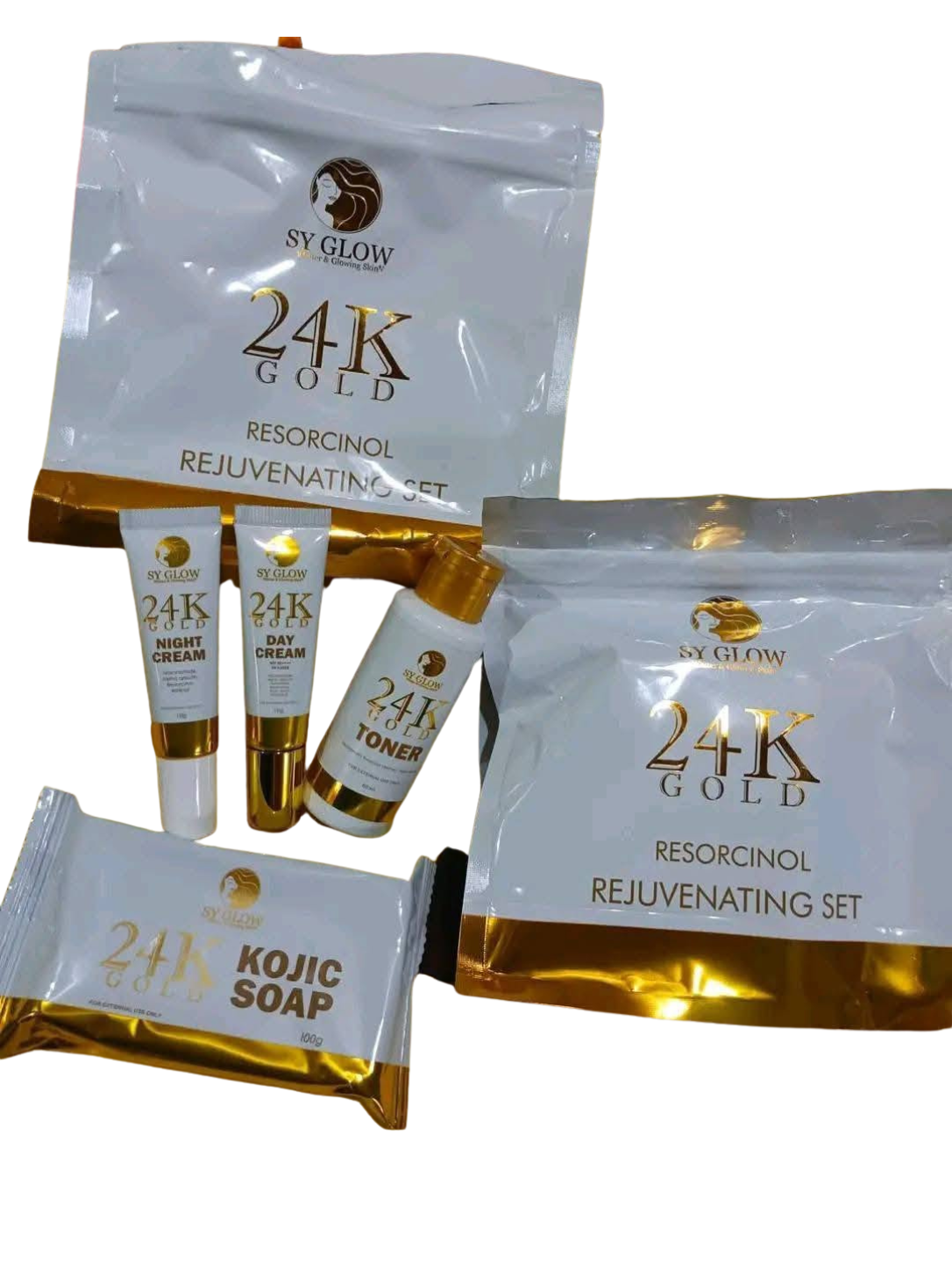 A 24K Gold Resorcinol Rejuvenating Set by SV GLOW, featuring a large resealable pouch, a smaller pouch, two small tubes (night cream and toner), and a bar of kojic soap, all in white and gold packaging.