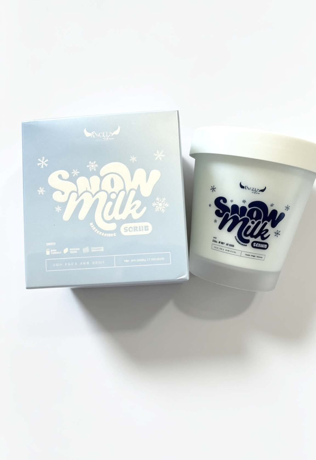 A frosted glass jar candle labeled 'Snow Milk' next to its light blue packaging box, set against a plain white background.