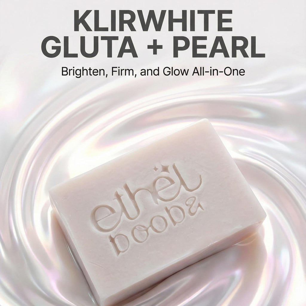 A rectangular bar of pale pink soap labeled 'ethel dooba' sits on a glossy iridescent surface with text above reading 'KLIRWHITE GLUTA + PEARL' and 'Brighten, Firm, and Glow All-in-One'.